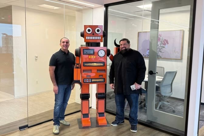 Ibrahem AlHaidari and Wa'il Ashshowwaf beside the orange UB17 robot